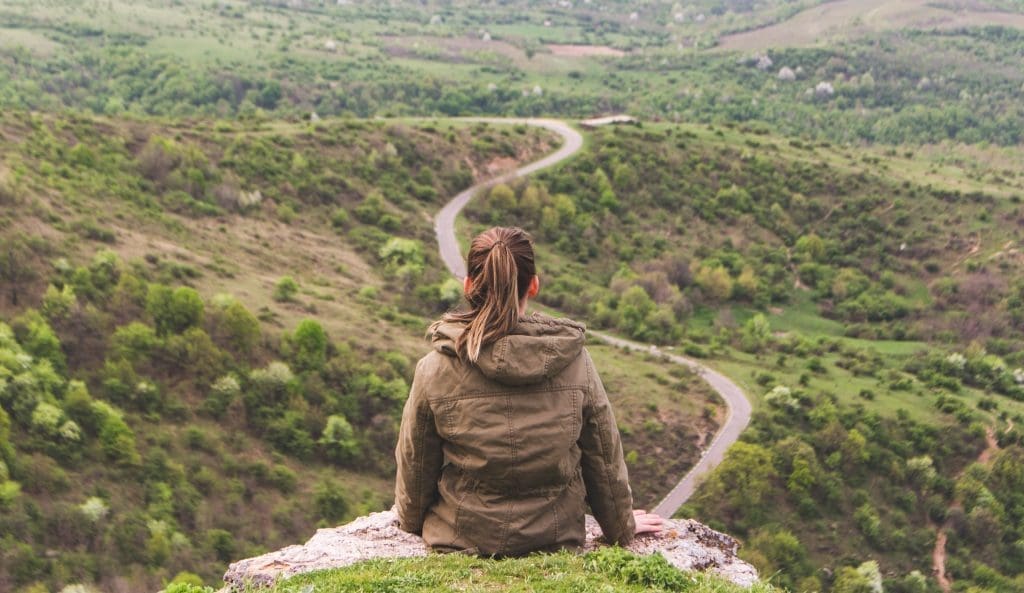 woman sitting on mountain top